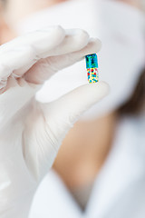 Image showing close up of scientist holding pill in lab