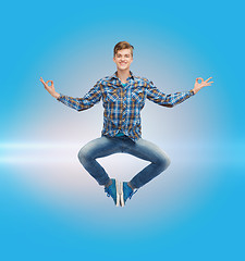 Image showing smiling young man jumping in air