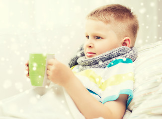 Image showing ill boy with flu in bed drinking from cup at home