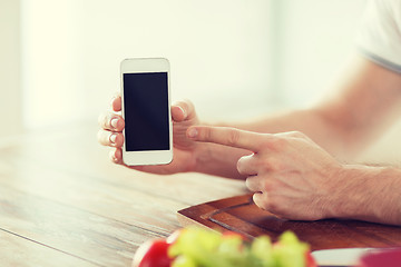 Image showing close up of male hands holding smartphone