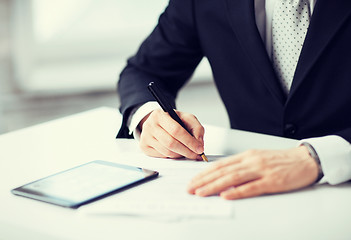 Image showing man with tablet pc signing paper