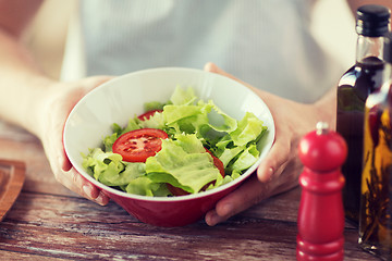 Image showing close of male hand holding a bowl with salad