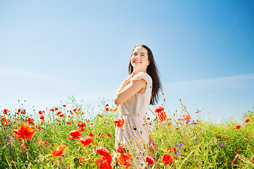 Image showing smiling young woman on poppy field