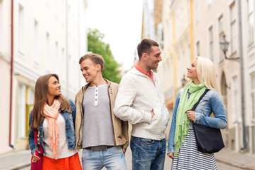 Image showing group of smiling friends walking in the city