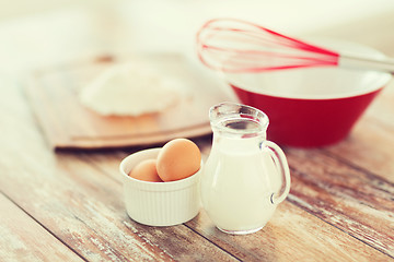 Image showing jugful of milk, eggs in a bowl and flour