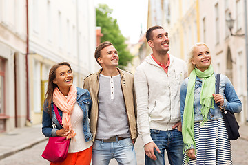 Image showing group of smiling friends walking in the city