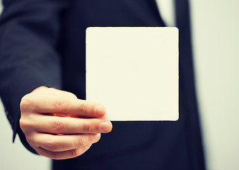 Image showing man in suit holding blank card