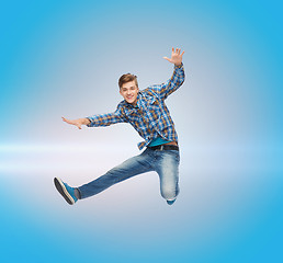 Image showing smiling young man jumping in air