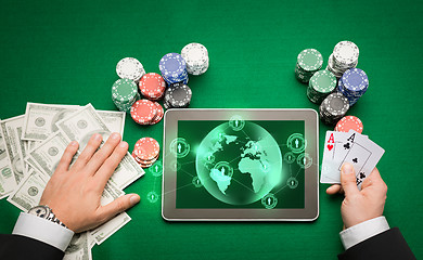 Image showing casino poker player with cards, tablet and chips