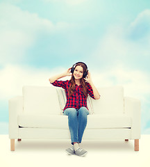 Image showing teenage girl sitting on sofa with headphones