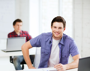 Image showing smiling student with laptop at school