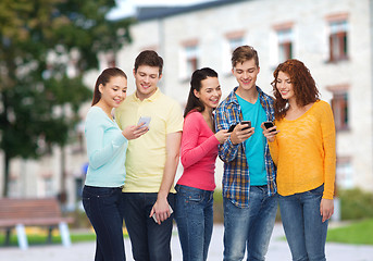 Image showing group of smiling teenagers with smartphones
