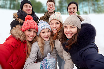 Image showing group of smiling friends taking selfie outdoors