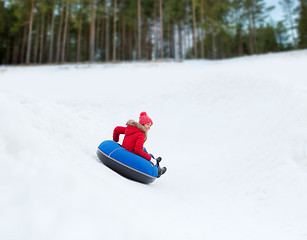 Image showing happy teenage girl sliding down on snow tube