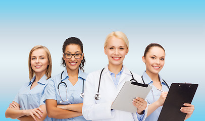 Image showing smiling female doctor and nurses with tablet pc