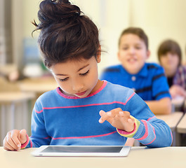 Image showing little school girl with tablet pc over classroom