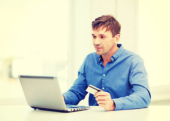 Image showing man with laptop and credit card at home