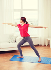 Image showing smiling teenage girl streching at home