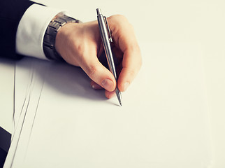 Image showing businessman writing something on the paper