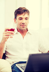 Image showing man with laptop computer and glass of rose wine