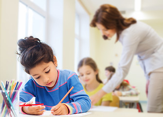 Image showing happy school girl drawing with coloring pencils