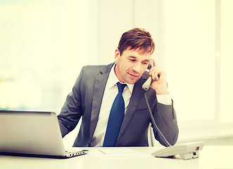 Image showing businessman with laptop computer and phone