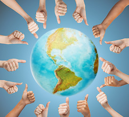 Image showing human hands showing thumbs up in circle over earth