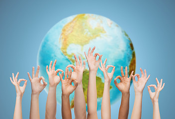 Image showing human hands showing ok sign over earth globe