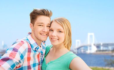 Image showing smiling couple taking selfie over bridge