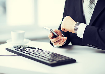 Image showing man hands with keyboard, smartphone and wristwatch