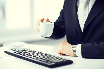 Image showing man hands with keyboard drinking coffee