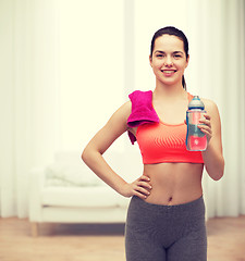 Image showing sporty woman with towel and water bottle