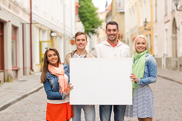 Image showing group of smiling friends with blank white board