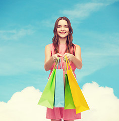 Image showing smiling woman in dress with many shopping bags