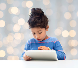 Image showing little girl with tablet pc over lights background