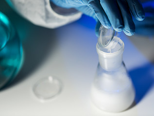 Image showing close up of hand pouring chemical into flask