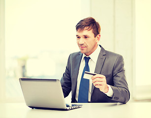 Image showing man with laptop and credit card in office