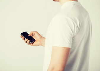 Image showing man with smartphone typing something