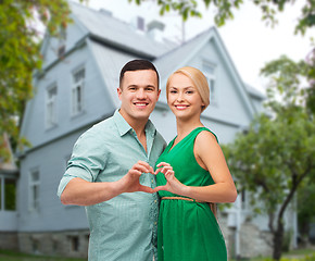 Image showing smiling couple and showing heart shape gesture