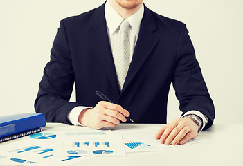 Image showing businessman working and signing with papers