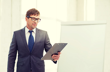 Image showing businessman pointing to flip board in office