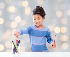 Image showing happy little girl drawing with coloring pencils