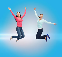 Image showing smiling young women jumping in air