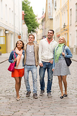 Image showing group of smiling friends walking in the city