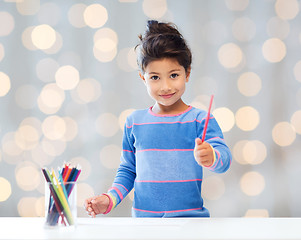 Image showing happy little girl drawing with coloring pencils