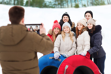 Image showing group of smiling friends with snow tubes