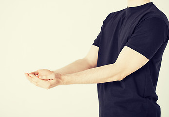 Image showing mans hands showing something