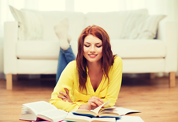 Image showing smiling student girl reading books at home