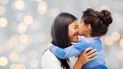 Image showing happy little girl hugging and kissing her mother