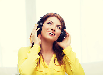 Image showing smiling young girl in headphones at home